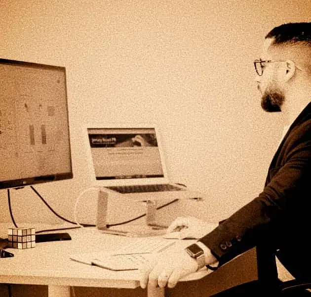 A professional workspace featuring dual monitors displaying complex GA4 data maps and a Rubik's cube, symbolizing the structured problem-solving required for higher ed attribution.
